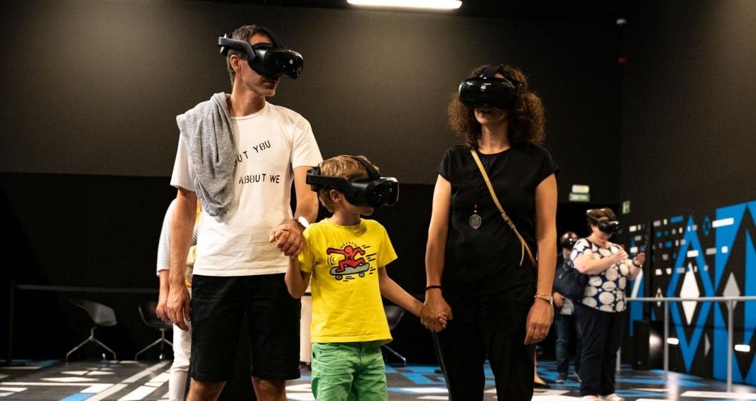 Room 07, Meta Verne — a family walking hand in hand through the free-roaming virtual reality metaverse wearing VR headsets